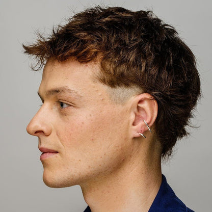 Photo of a model Jasper Derluyn who is wearing the Gloria earrings, part of the Icons jewelry collection, by Aurore Havenne.