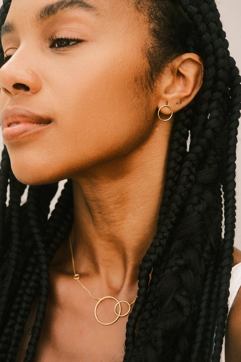 Claudie Silva Conceiçao porte les boucles d'oreilles Small Circle en argent plaqué or créées par Aurore Havenne