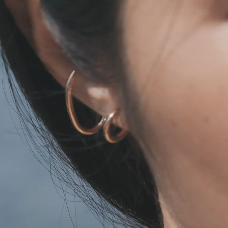 Video of a model who is wearing the Gloria earrings, part of the Icons jewellery collection, designed by Aurore Havenne. It is a pair of earrings in gold plated silver.