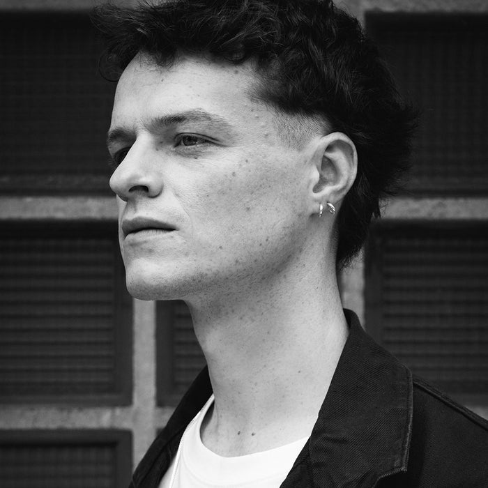 Black and white photo of a model who is wearing the Charlie earrings, part of the Icons jewellery collection, designed by Aurore Havenne. It is a pair of earrings in 925°°° silver.