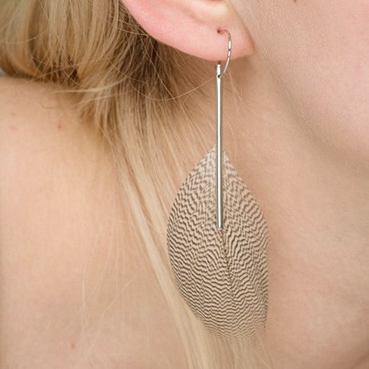 Boucle d'oreille en argent avec une plume blanche, collaboration entre 2 créatrices